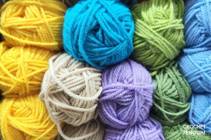 Susan-Bates-Tunisian-Crochet-Hooks - image of balls of yarn in blue, yellow, green and purple